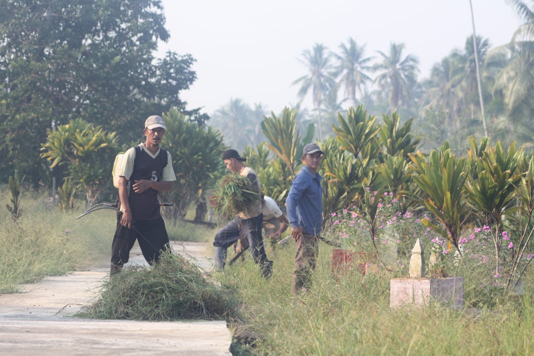 Jelang Idul Adha, Mahasiswa KKL IAIN Pontianak Ajak Warga Bersihkan Makam